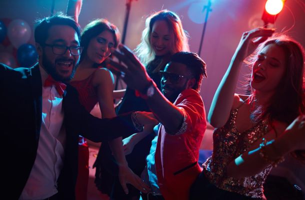 Gut gelaunte Menschen tanzen in einem Club.